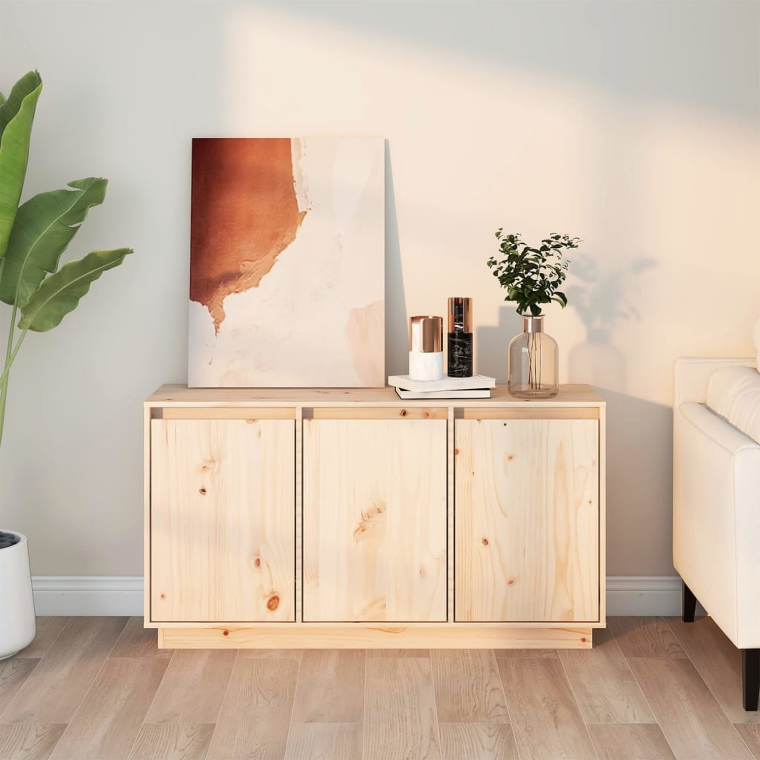 Holzschrank mit drei Türen, ein Gemälde, eine Vase mit Blumen und eine Pflanze. Heller Holzboden.