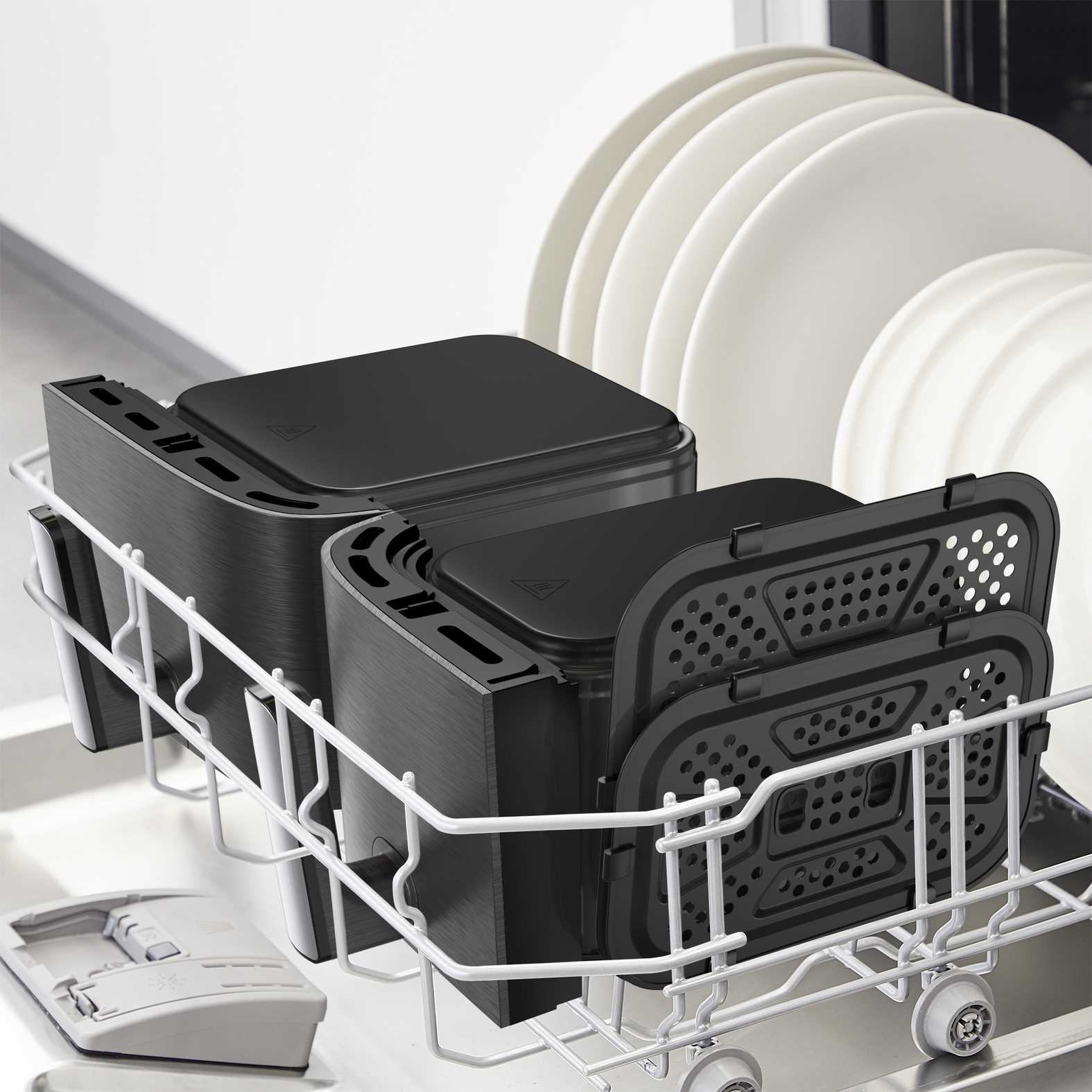 Onderdelen van een airfryer in een vaatwasserrek, klaar om te worden schoongemaakt.