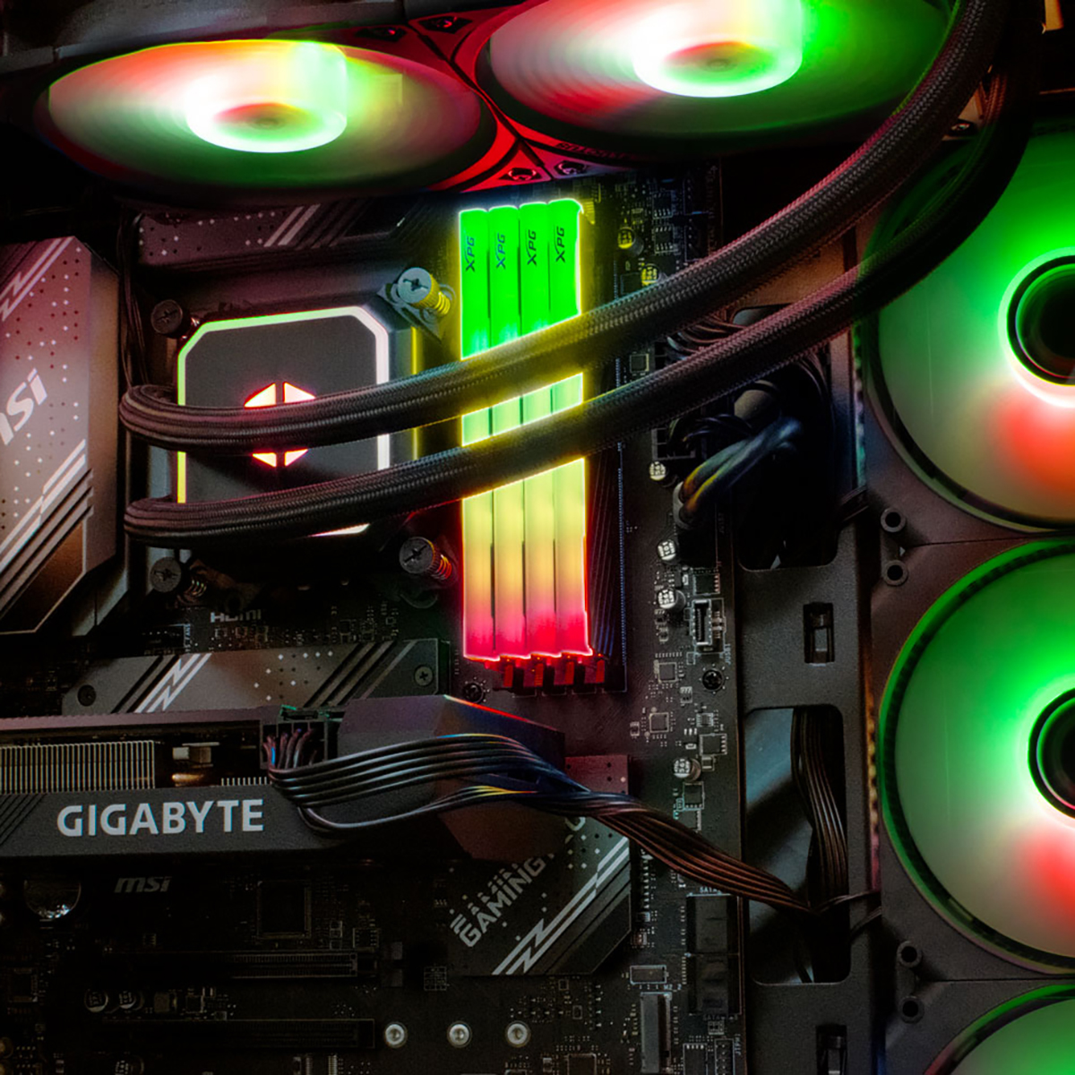 Dentro de una caja de computadora, mostrando una placa base, ventiladores y módulos RAM coloridos.