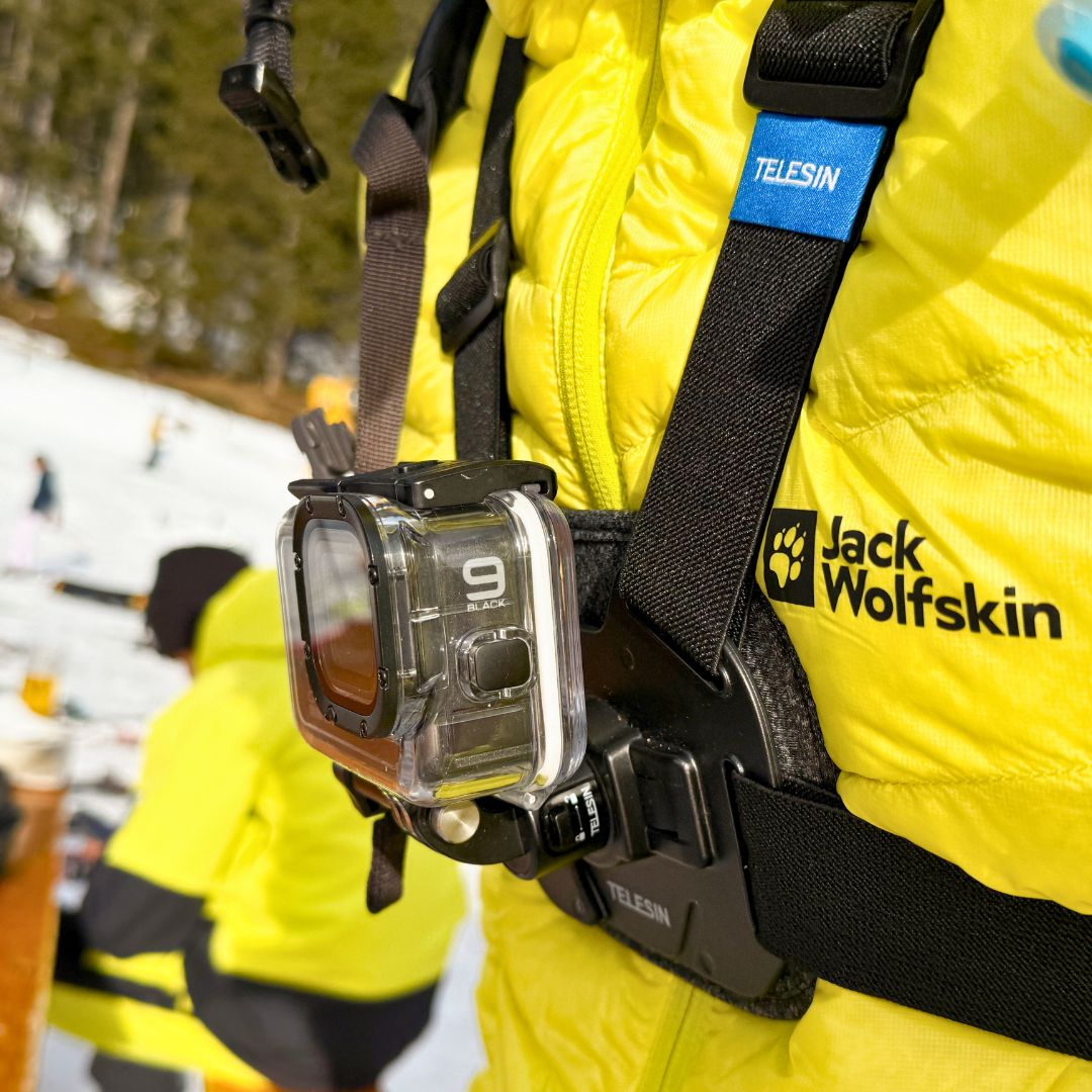Persoon draagt gele jas met GoPro camera bevestigd aan borstbevestiging.