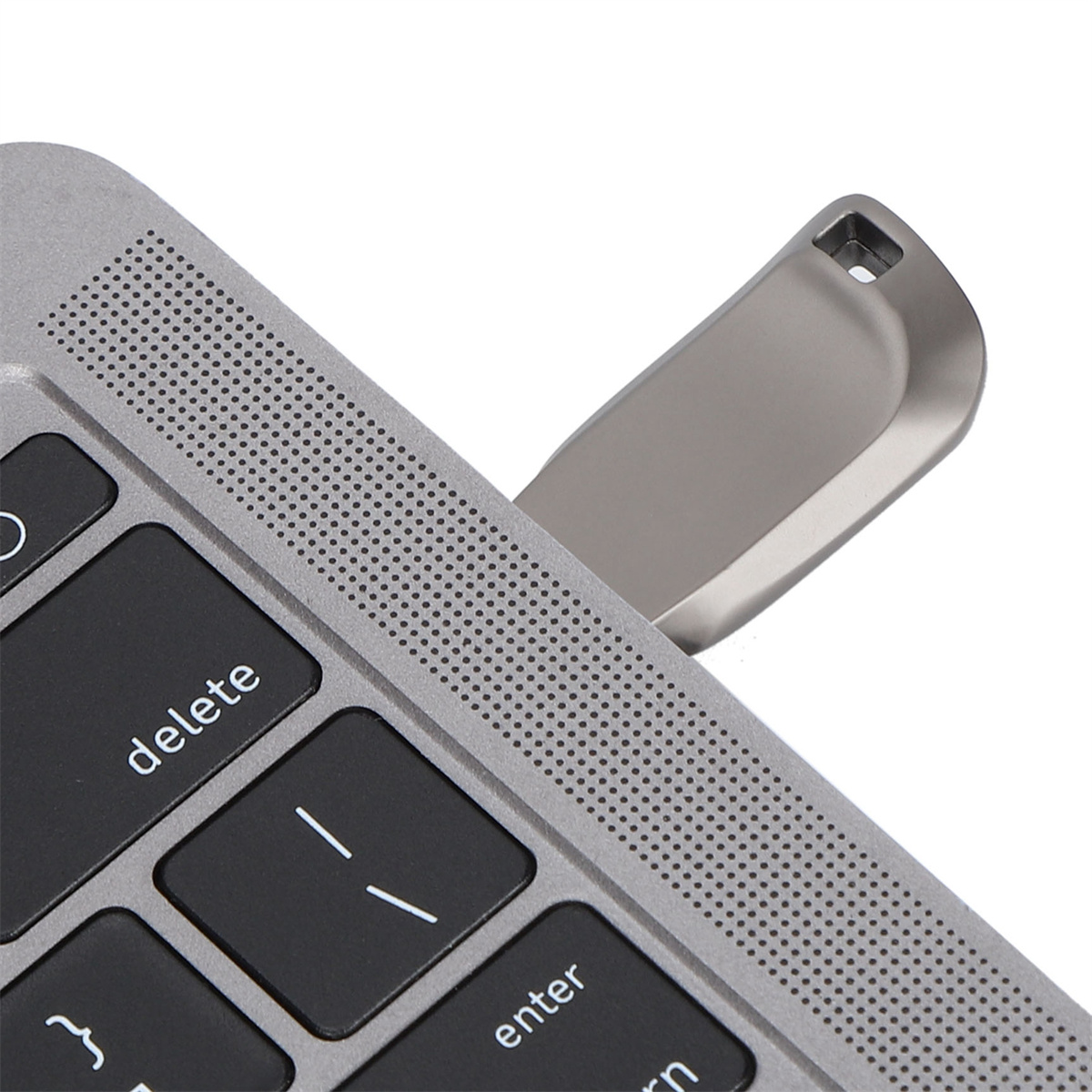 Ein silberner USB-Stick, der in den USB-Anschluss eines Laptops gesteckt wird.