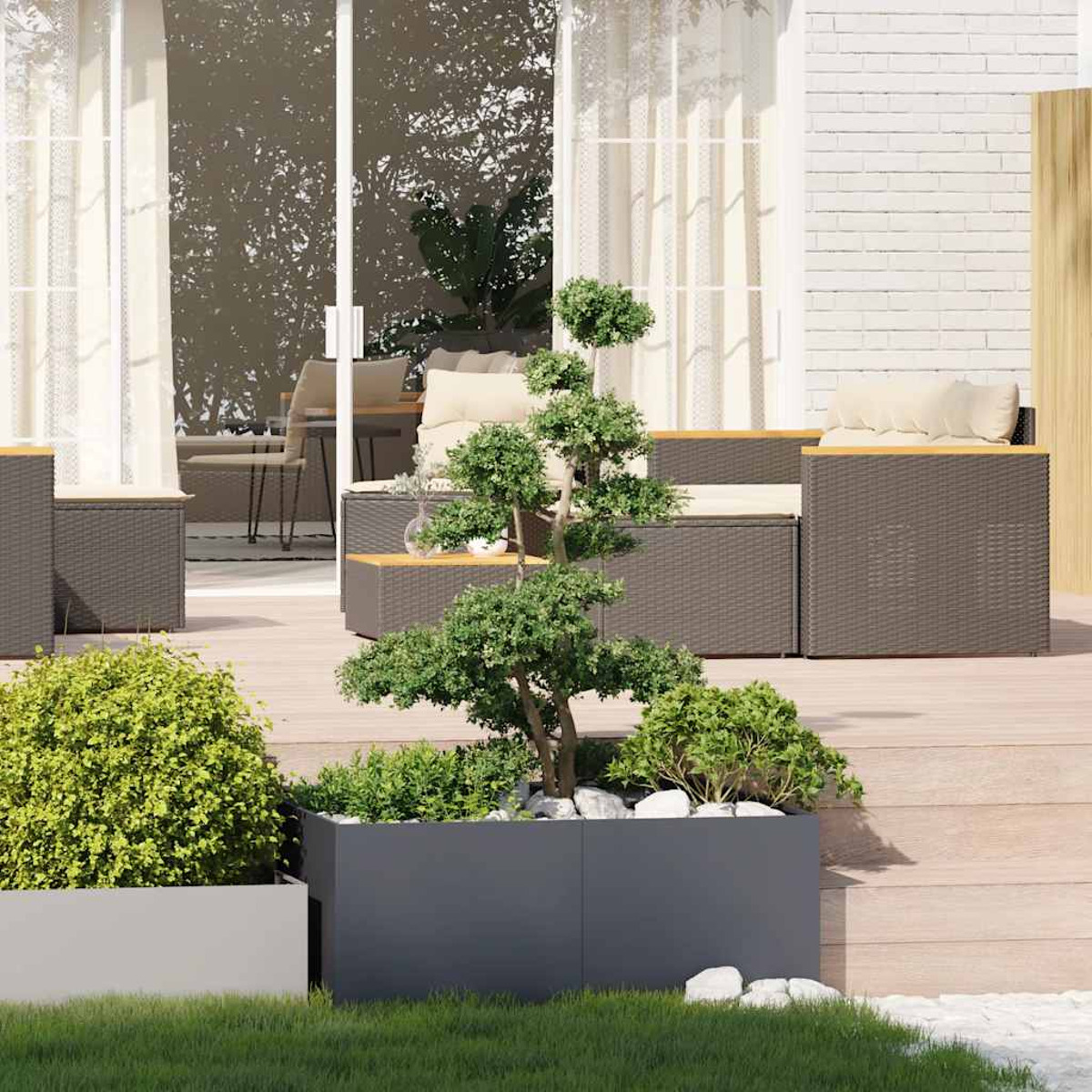 Un albero bonsai in una fioriera su un ponte di legno. I mobili da esterno sono visibili sullo sfondo.
