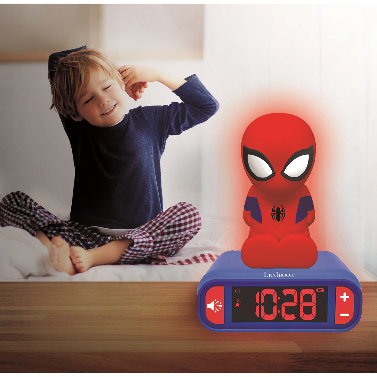 Niño en pijama se estira cerca de un despertador de Spider-Man. El reloj muestra la hora, brillando en rojo con una figura de Spider-Man.