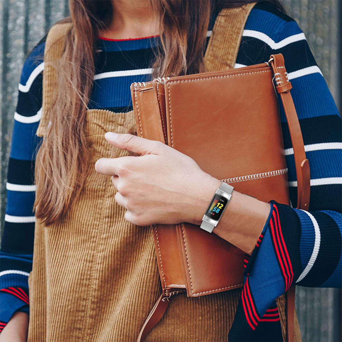 Donna con smartwatch e borsa marrone.