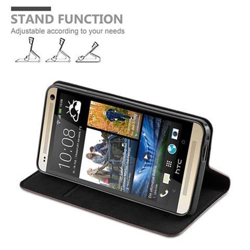 Teléfono en una funda, soporte abierto. Teléfono negro, pantalla mostrando hora e iconos. La funda es marrón.