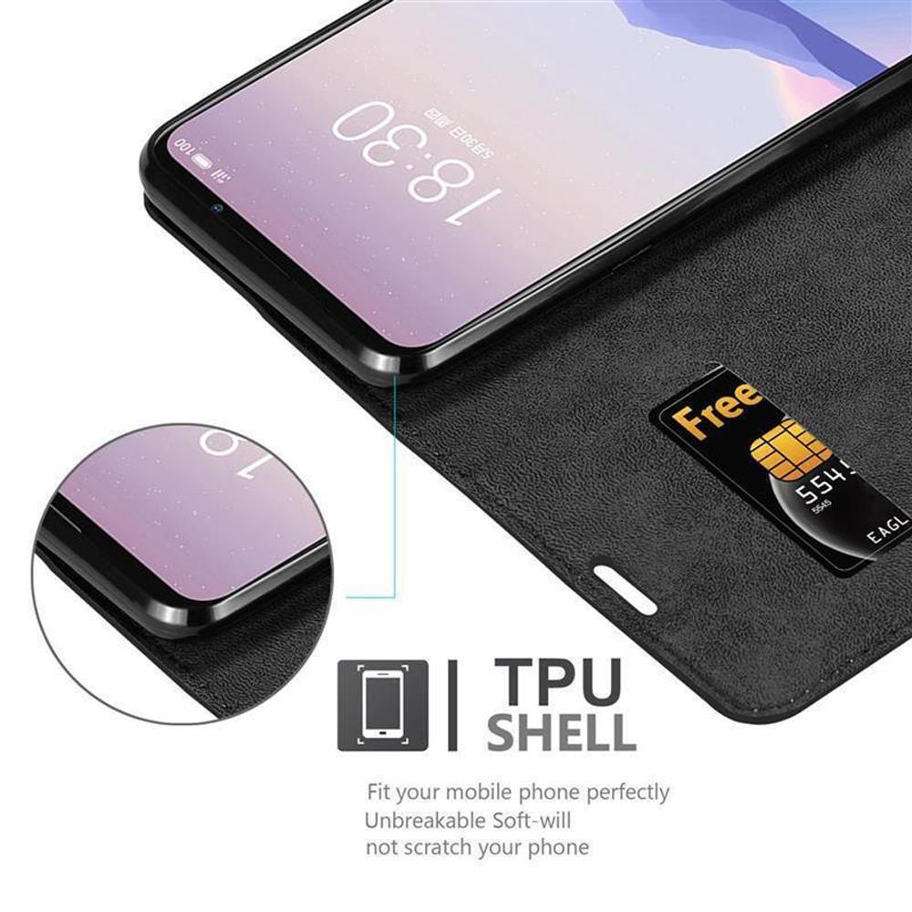 Un teléfono con una funda negra. Hay una tarjeta en la funda con un letrero de 'gratis'. Se muestra la hora.