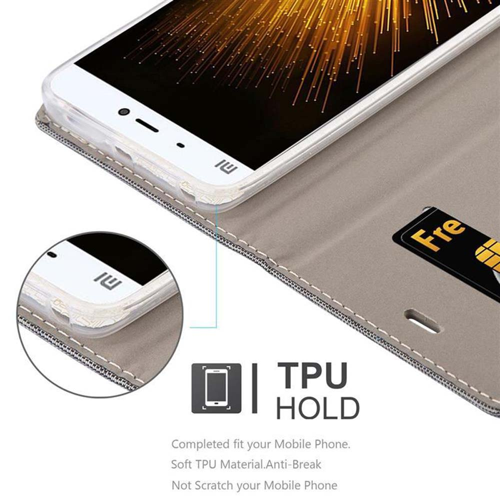 Telefon in einem Gehäuse. Ein kreditkartenähnlicher Gegenstand ist sichtbar. Das Gehäuse ist grau.