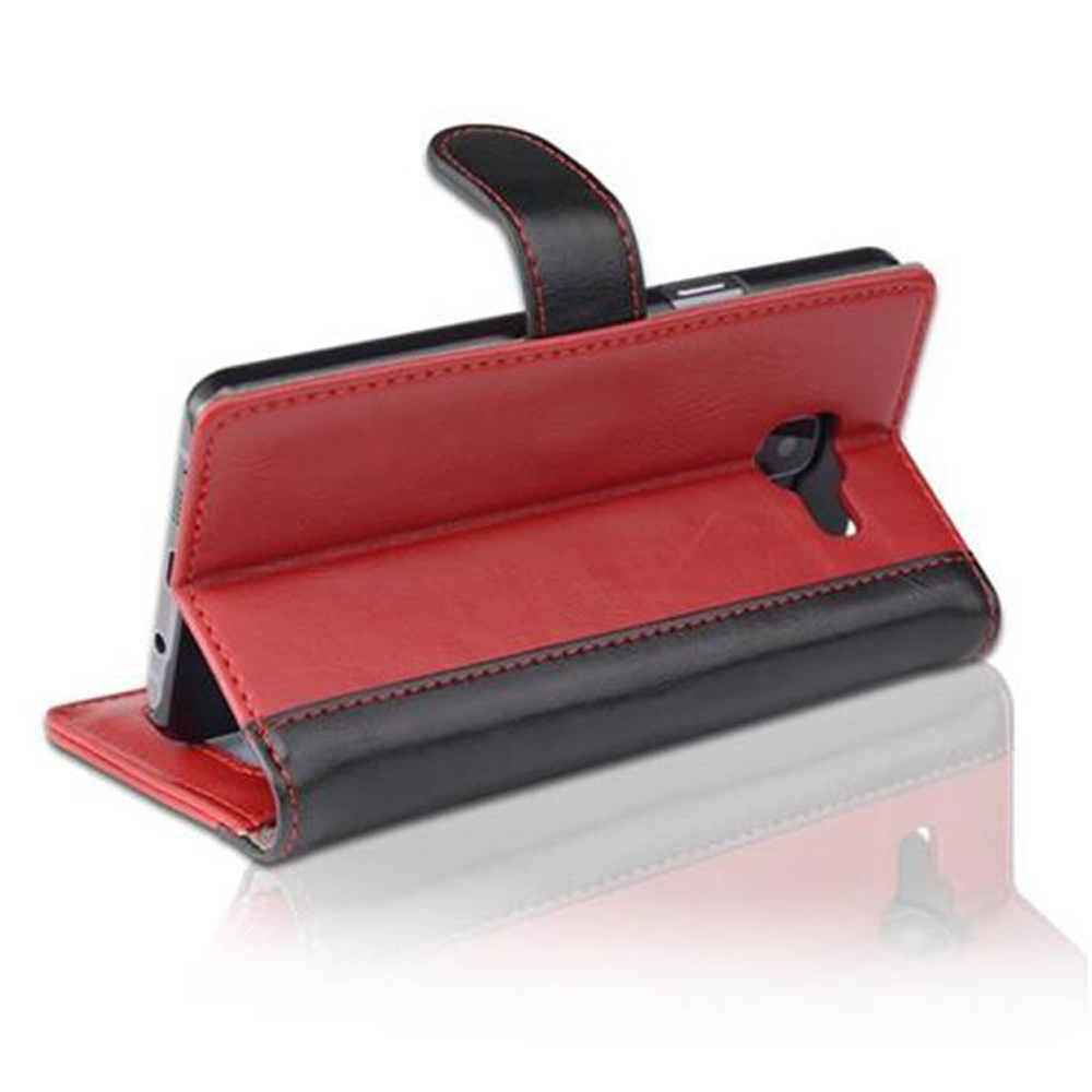 Funda de teléfono, cuero rojo y negro. El teléfono está dentro. Reflejo visible.
