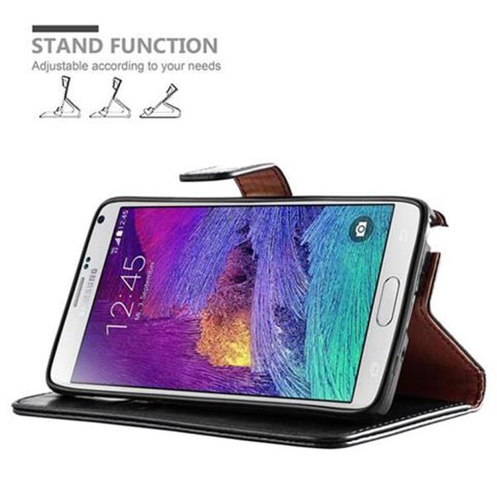 Un telefono in una custodia nera, puntellato, che mostra lo schermo con l'ora visualizzata.