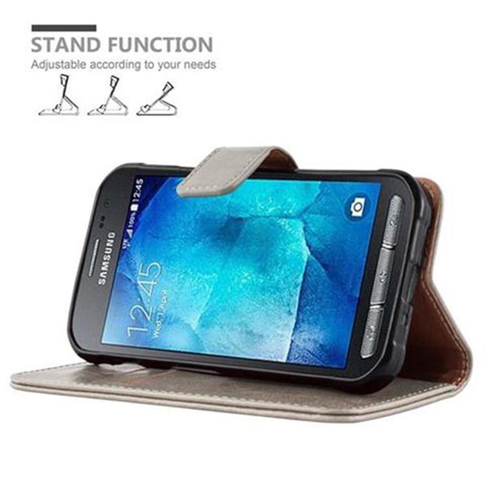 Telefono Samsung nero in una custodia marrone aperta. Testo funzione stand e piccole icone sono visibili.