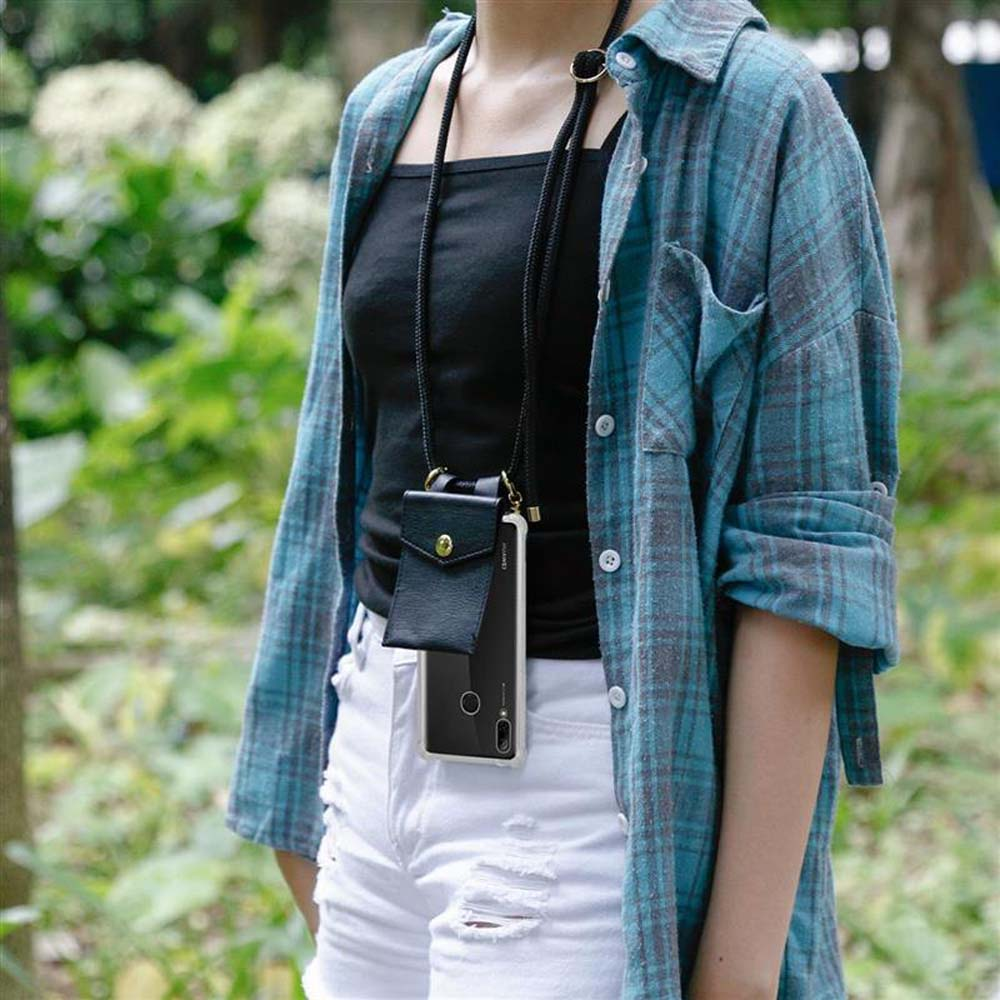 Una donna con una camicia a quadri blu e pantaloncini bianchi. Ha un telefono in una custodia di pelle appesa al collo.