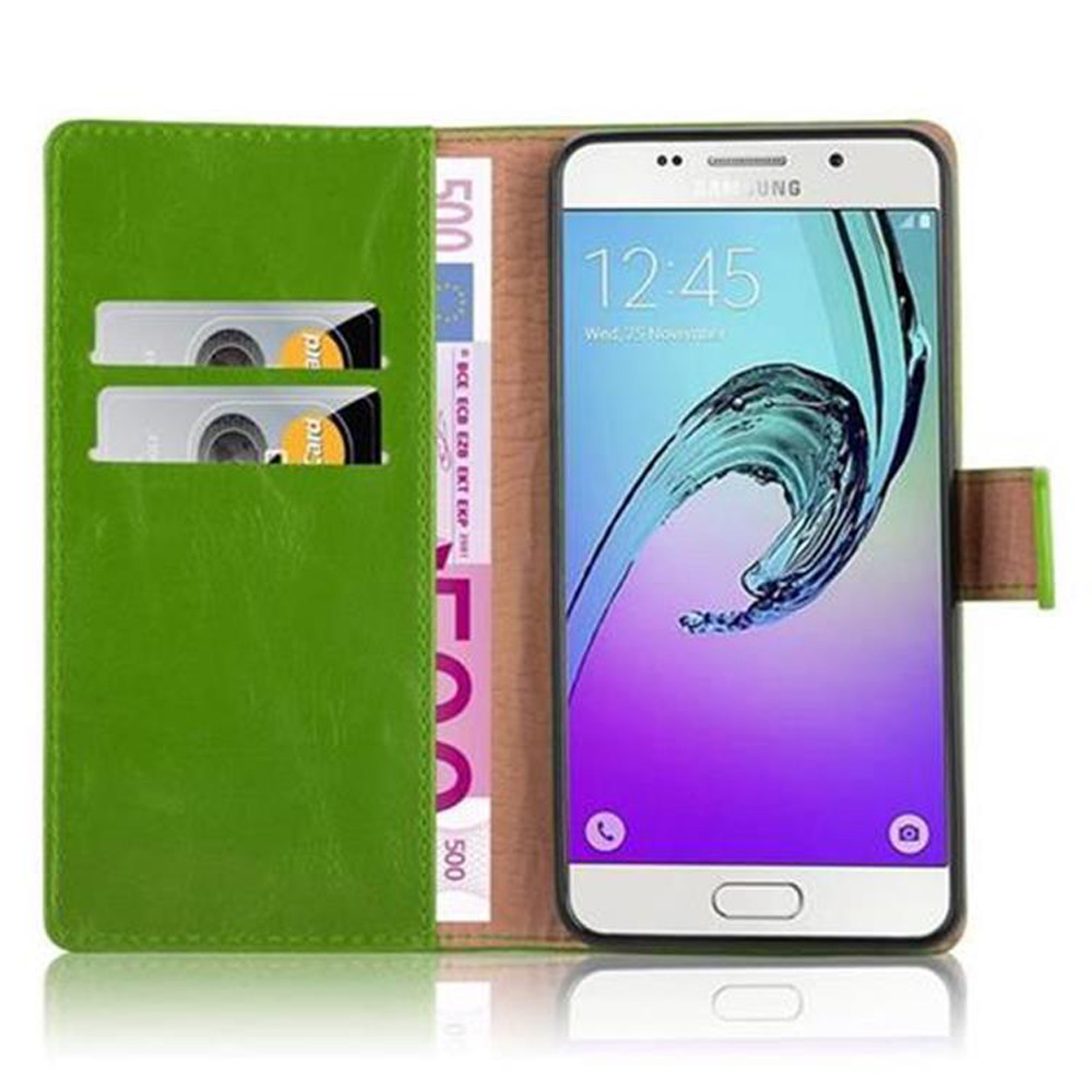 Una funda verde para teléfono con un teléfono dentro. Tiene ranuras para tarjetas y billetes de euro dentro. El teléfono muestra la hora.