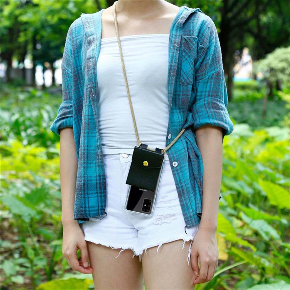 Una donna in pantaloncini bianchi e camicia a quadri blu indossa una custodia per telefono su un cordino dorato.