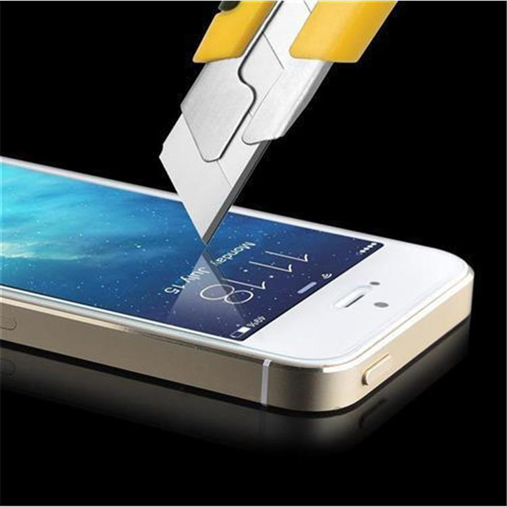 Ein Teppichmesser schneidet die Displayschutzfolie auf einem Telefon.