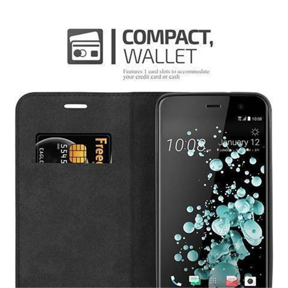 Ein schwarzes Telefon befindet sich in einem Gehäuse mit Kartensteckplatz. Der Bildschirm zeigt Uhrzeit und Datum an.