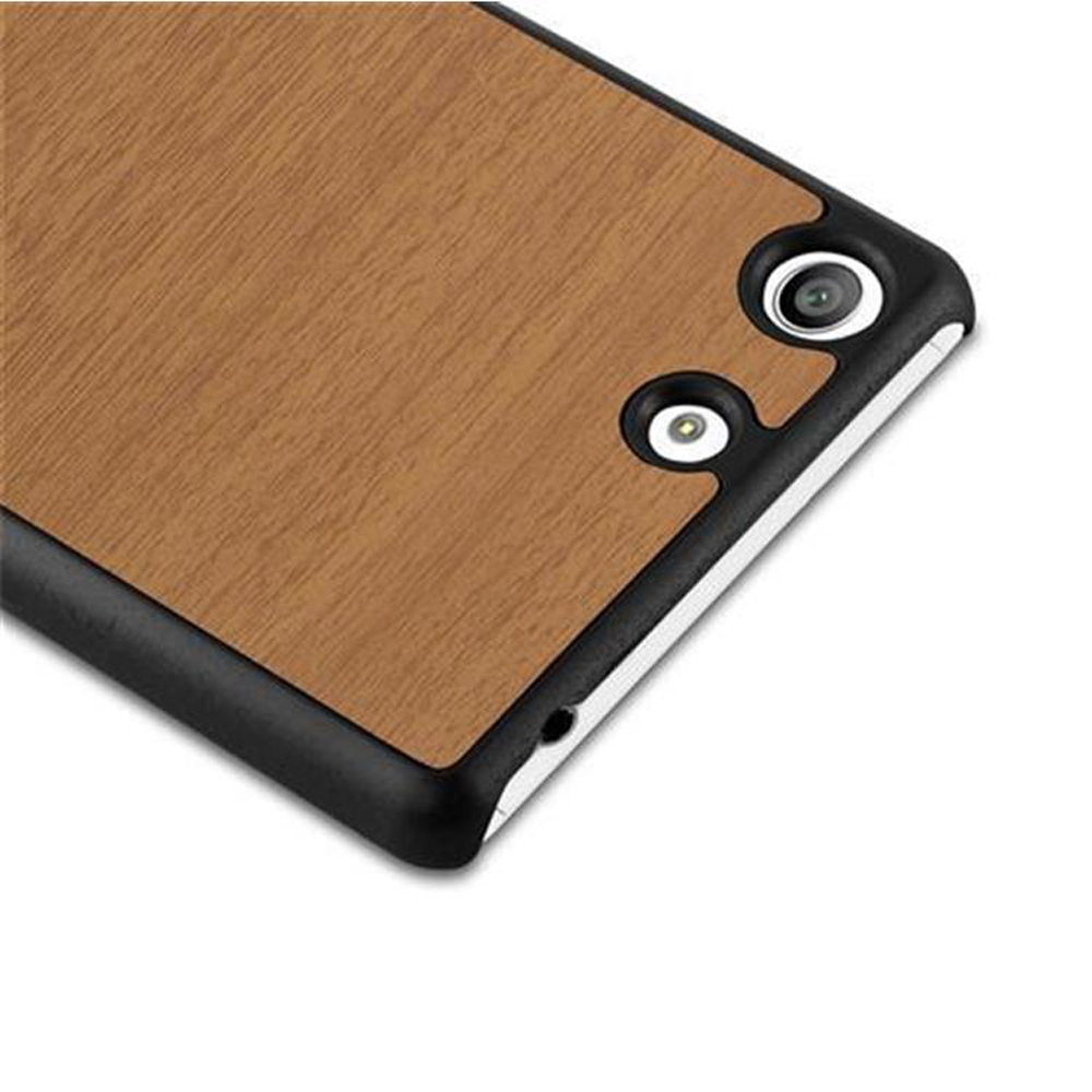 Primer plano de la funda del teléfono. Diseño de vetas de madera con borde negro. Se ven dos orificios para la cámara y uno para el flash.