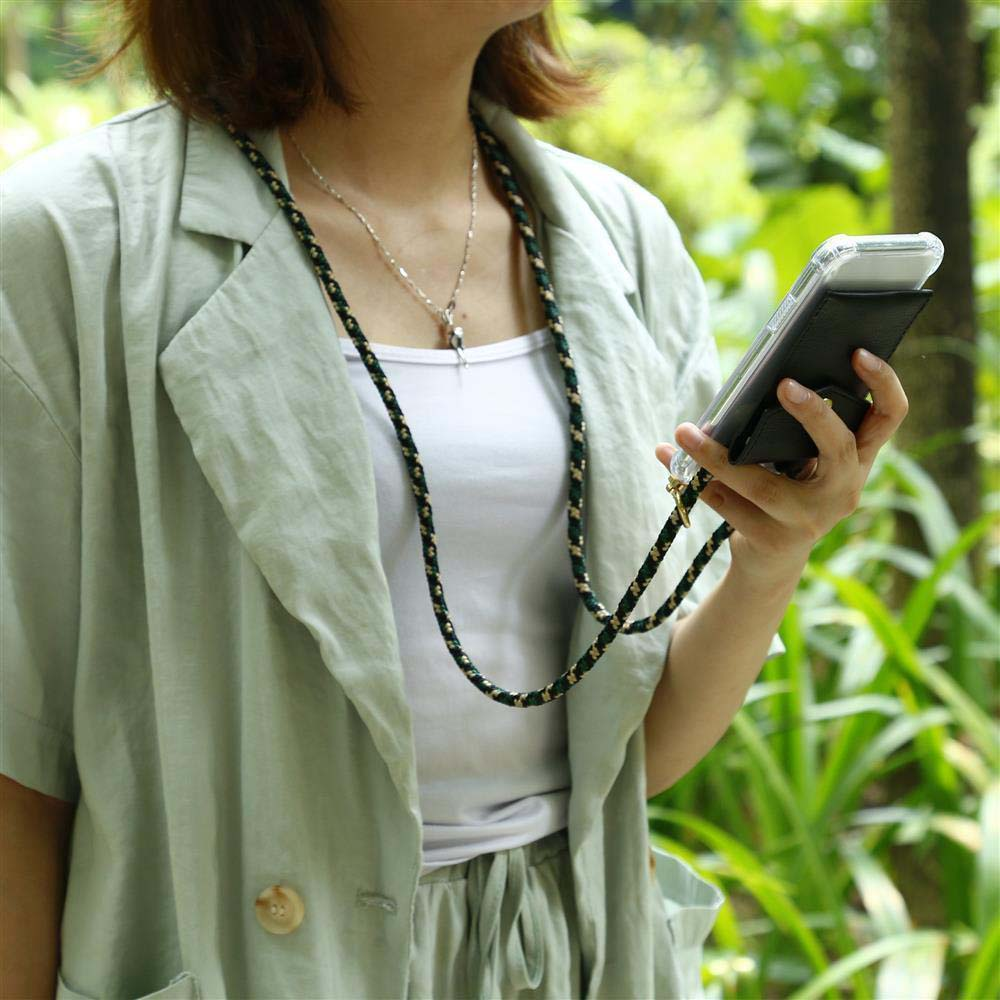 Una persona che tiene un telefono in una custodia nera con un cinturino verde e oro. Lo sfondo è sfocato.