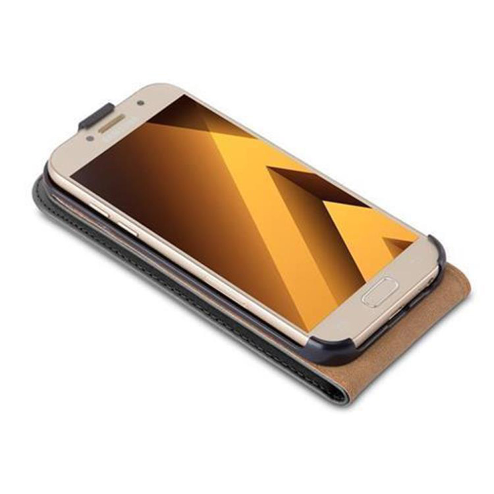 Telefono in una custodia, su un tavolo. Telefono dorato con schermo giallo, su una custodia marrone e nera. Ingranaggi sullo sfondo.