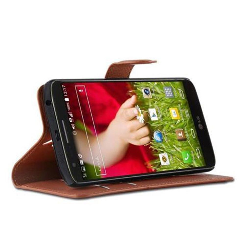 Telefon mit Babyhand. Es ist in einer braunen Lederhülle. Der Bildschirm zeigt grünen Hintergrund.