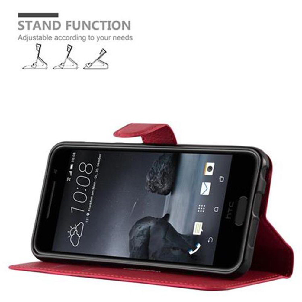 Telefono in custodia rossa, schermo che mostra l'ora. Il telefono è angolato. Icone funzione stand sopra.