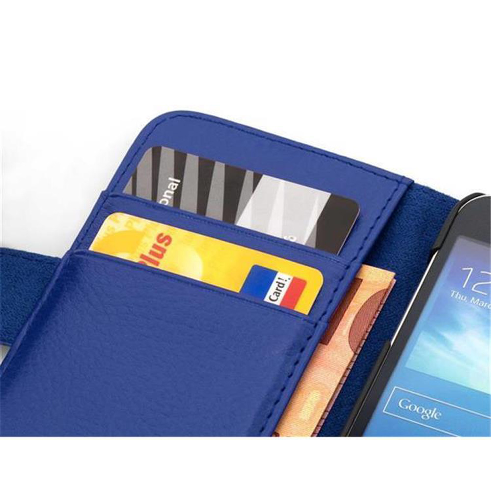 Una funda de teléfono azul abierta, con tarjetas y dinero dentro. Un teléfono a la derecha.