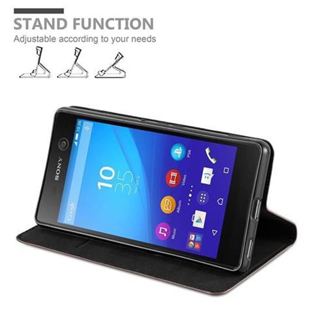 Teléfono negro en funda negra, abierto. Gráfico de función de soporte en la parte superior. El teléfono muestra la hora, iconos de aplicaciones y Google.
