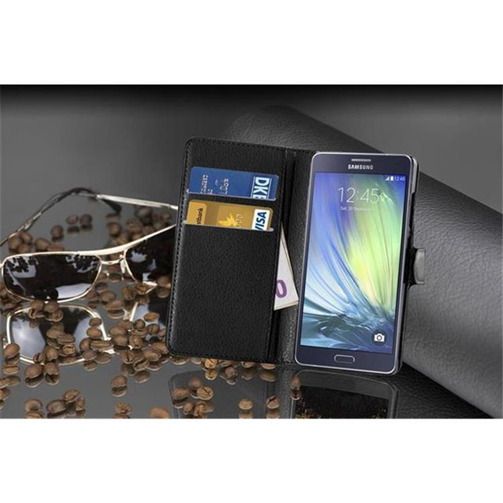 Una custodia nera per telefono aperta, con occhiali da sole, chicchi di caffè e un telefono con carte all'interno.