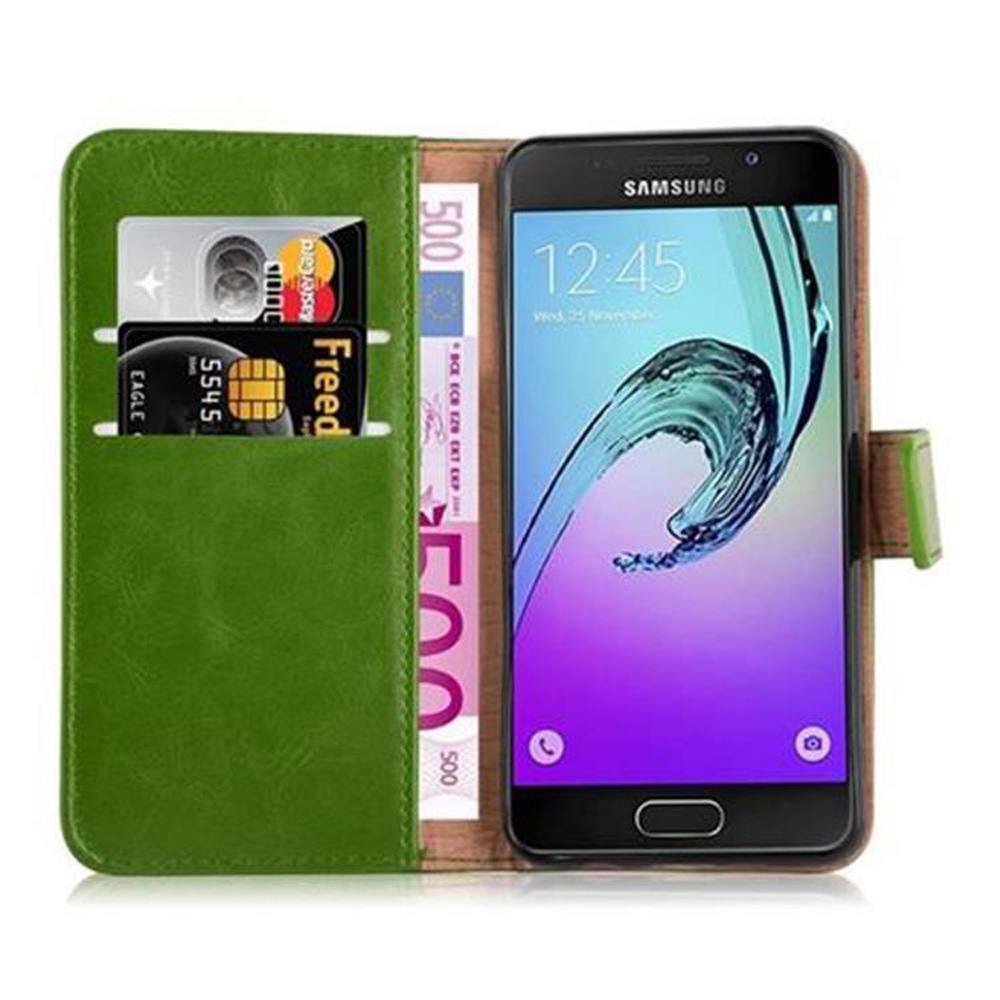 Funda verde para teléfono con teléfono dentro. Tarjetas de crédito y efectivo visibles. Fondo marrón.