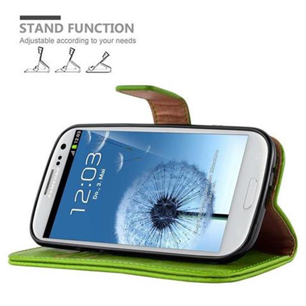 Teléfono en funda verde, inclinado hacia arriba. Pantalla muestra reloj y diseño floral. Texto: Función Soporte.