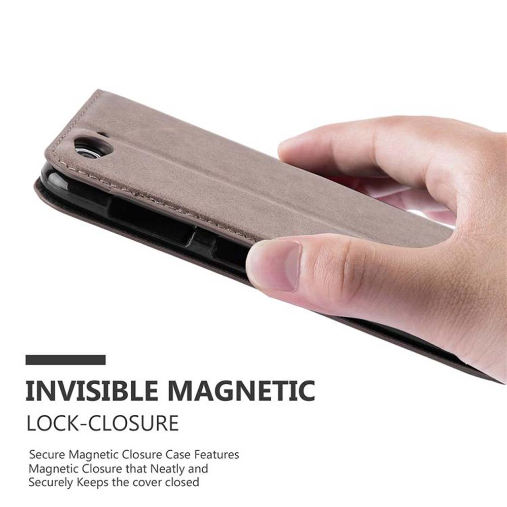Mano che tiene una custodia marrone, che mostra la chiusura magnetica.