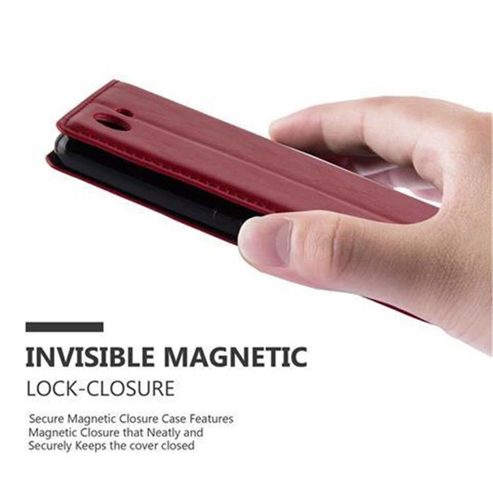 Mano sosteniendo una funda burdeos. Texto: Cierre magnético invisible.