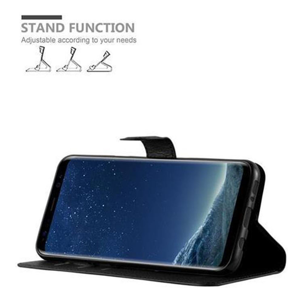 Schwarzes Telefon in schwarzer Hülle, hochgestellt. Der Bildschirm zeigt ein Landschaftsbild. Text oben sagt Standfunktion.