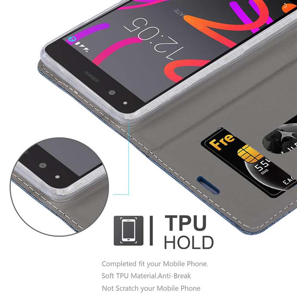 Teléfono en una funda de cartera gris. Una tarjeta de crédito está en la ranura. La pantalla del teléfono muestra 12:05. El texto dice 'TPU HOLD'.