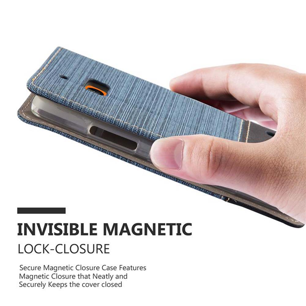 Mano che tiene una custodia per telefono in denim blu. La custodia ha una chiusura magnetica. Sfondo bianco.