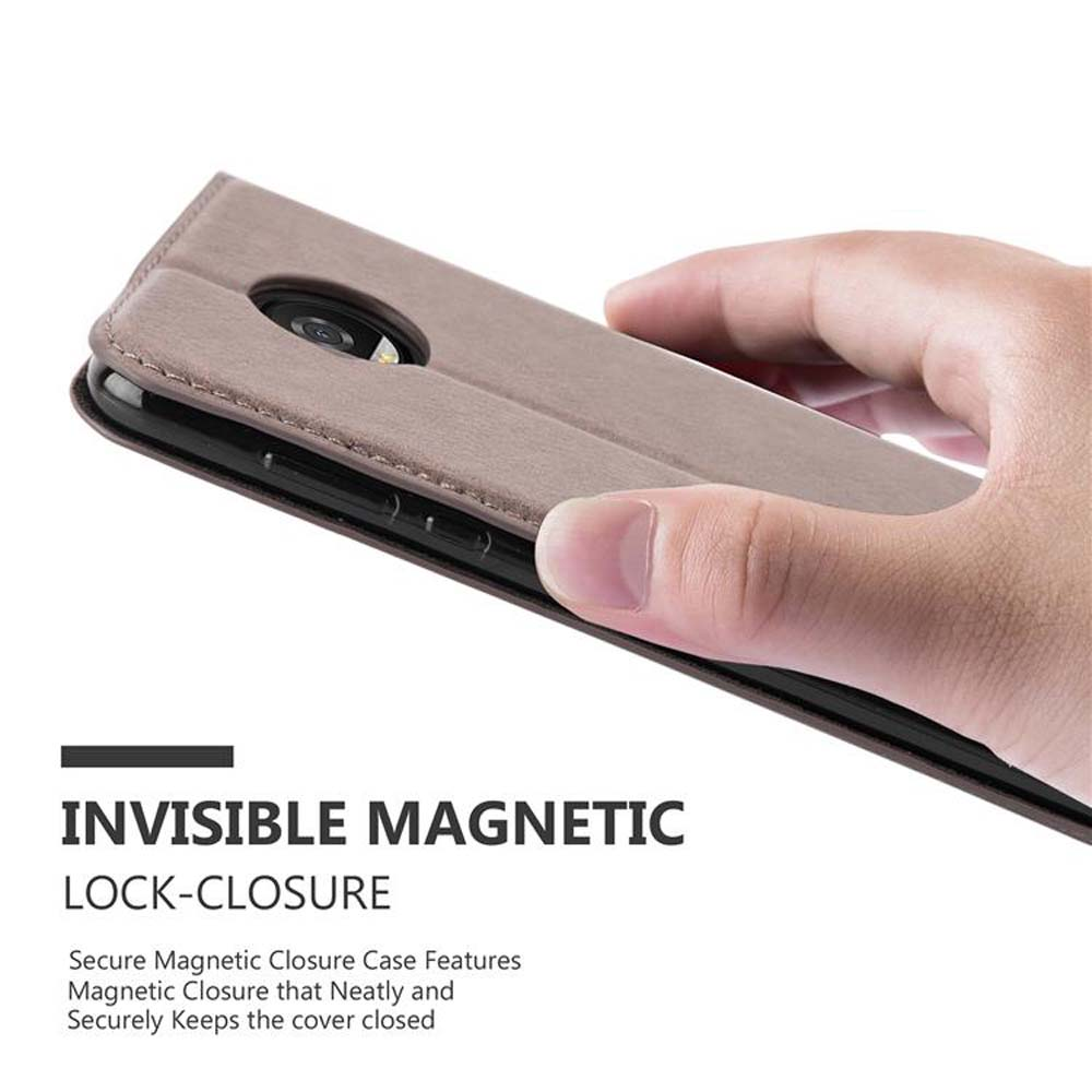 Una mano tiene una custodia marrone per telefono. Il testo dice chiusura magnetica invisibile. Il telefono è dentro.
