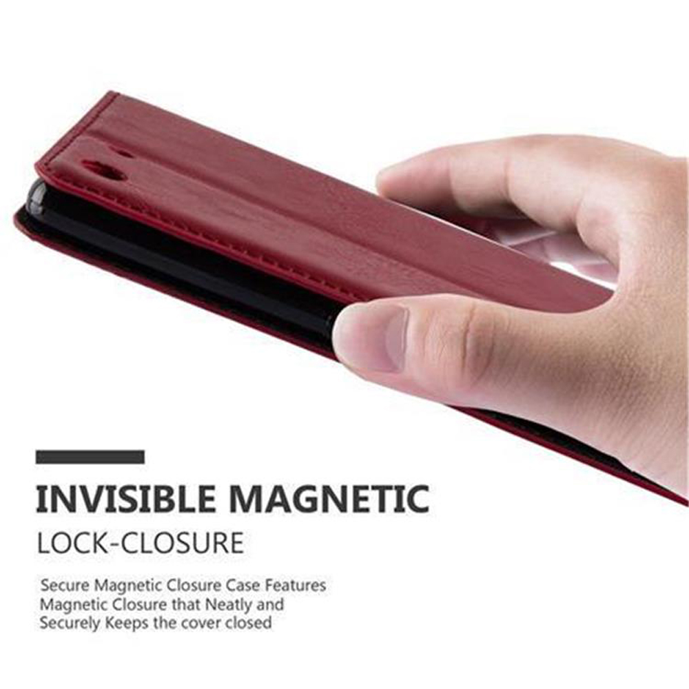 Funda de teléfono burdeos cerrándose con una mano. Cierre magnético invisible para una sujeción segura.