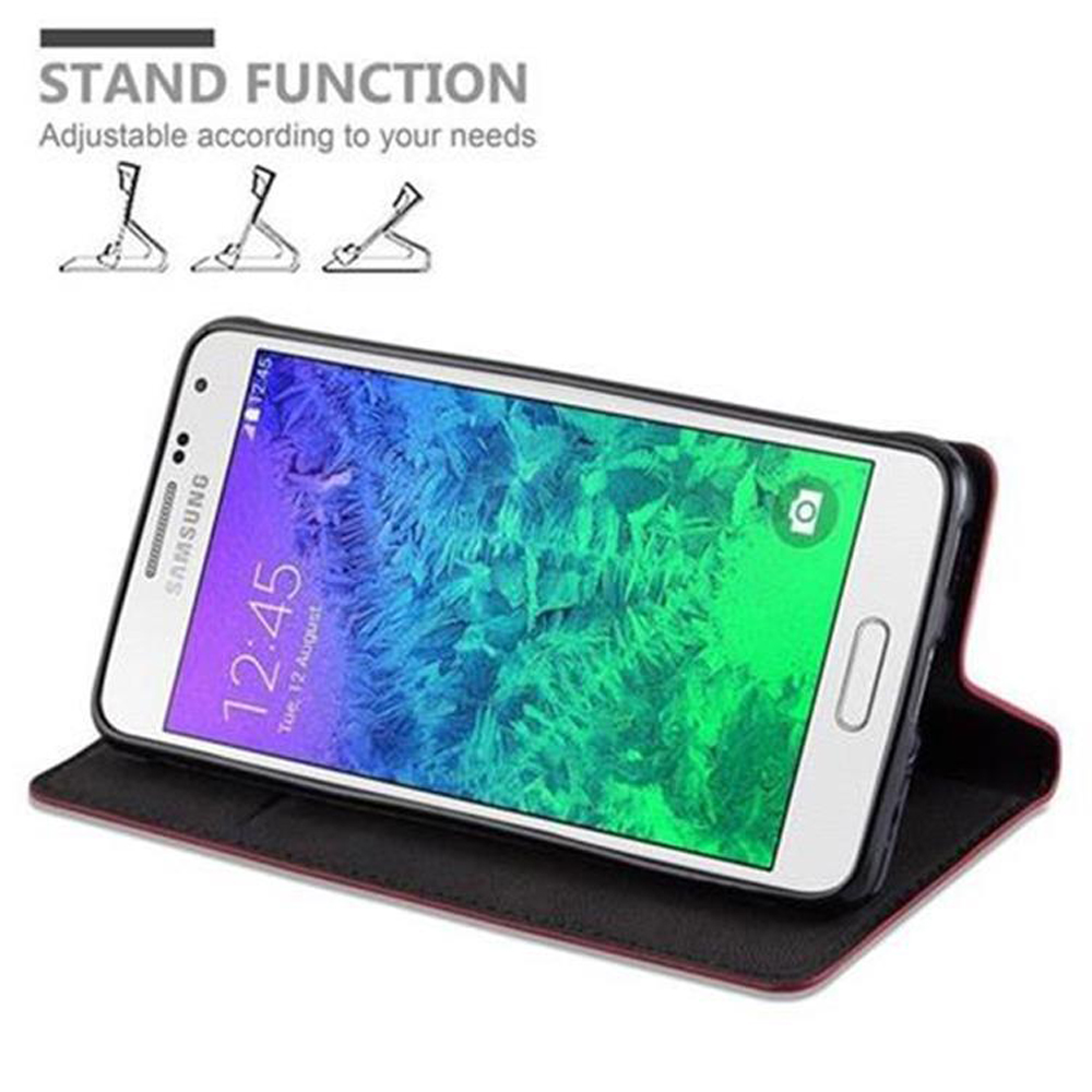 Un teléfono en un soporte, con la pantalla mostrando la hora, y la funda es roja.