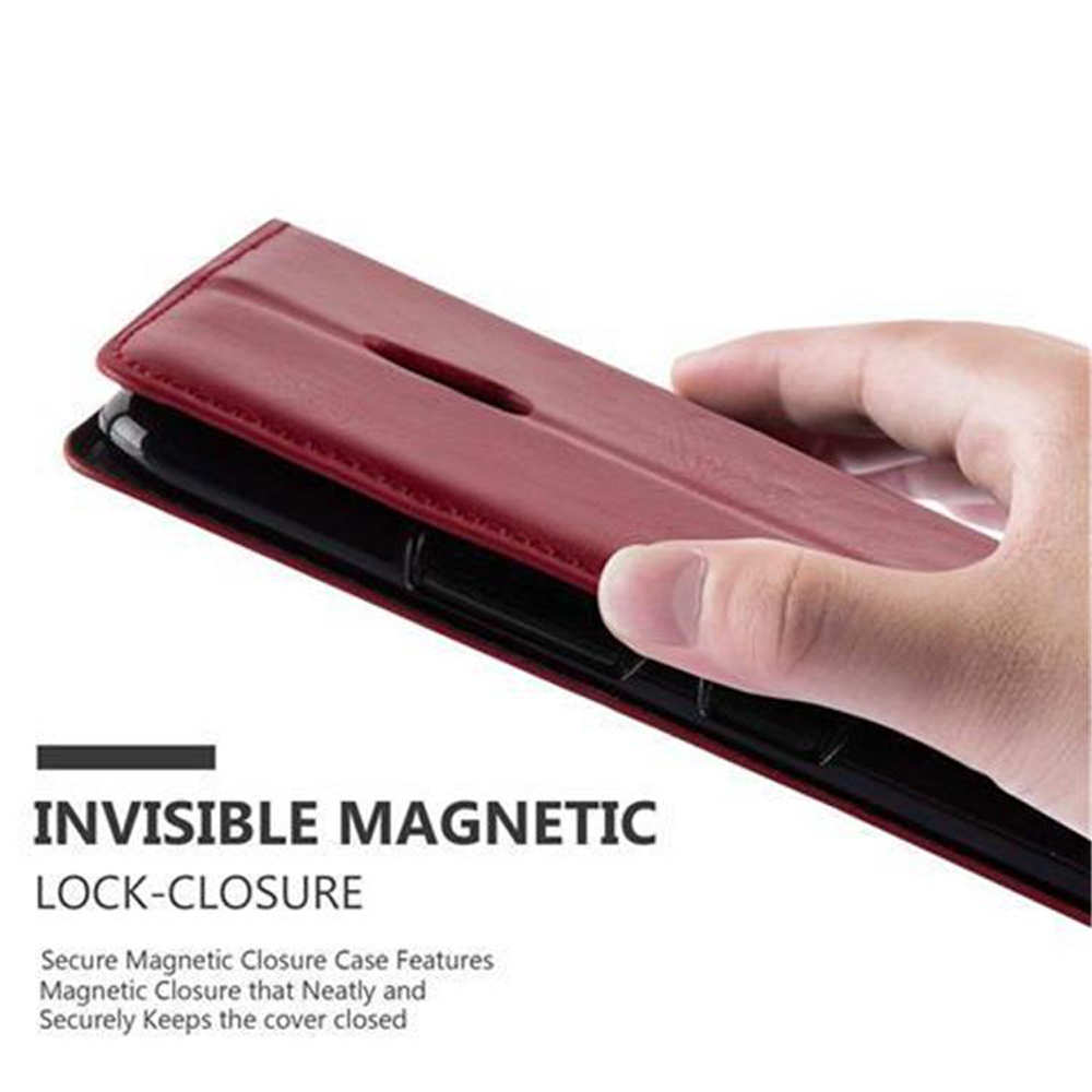Mano che tiene una custodia per telefono chiusa. La custodia è rossa, con chiusura magnetica.