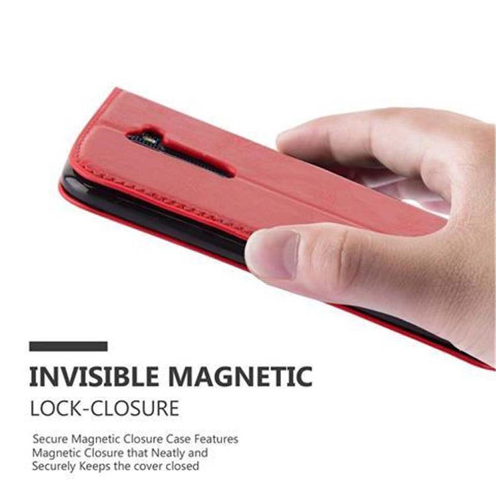 Una mano che tiene una custodia rossa chiusa. Testo: Chiusura magnetica invisibile.