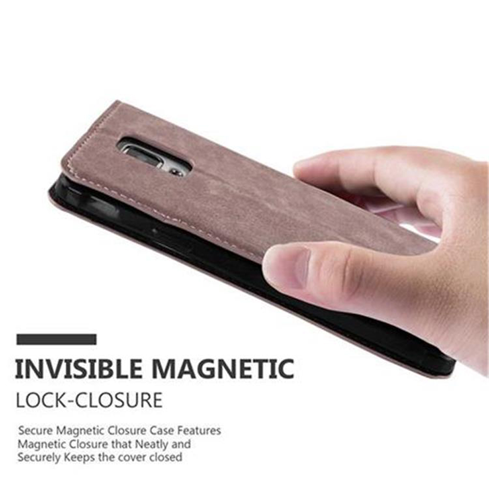 Hand hält braune Handyhülle mit Magnetverschluss. Der Hintergrund ist weiß.