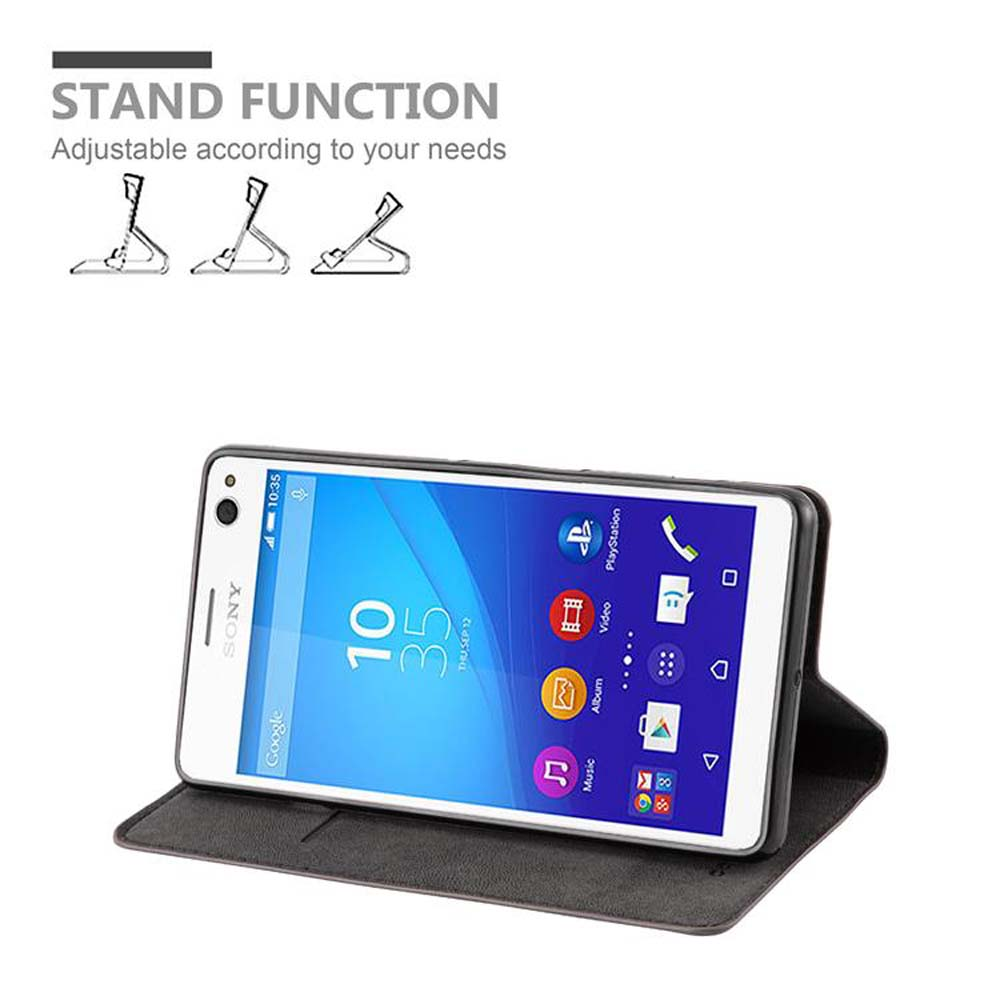 Teléfono en funda, inclinado hacia arriba. La funda es negra. Se anuncia la función de soporte. El teléfono muestra la fecha y la hora.