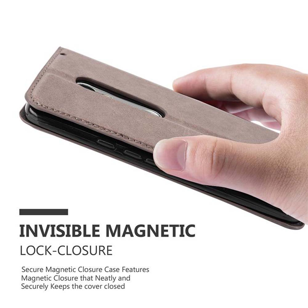 Mano che tiene aperta una custodia grigia. Chiusura magnetica visibile.