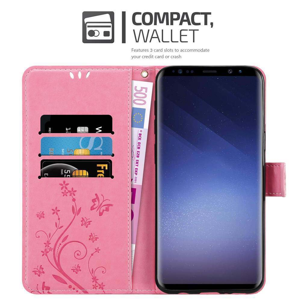 Una custodia rosa con carte, denaro e un telefono all'interno. Design floreale visibile.