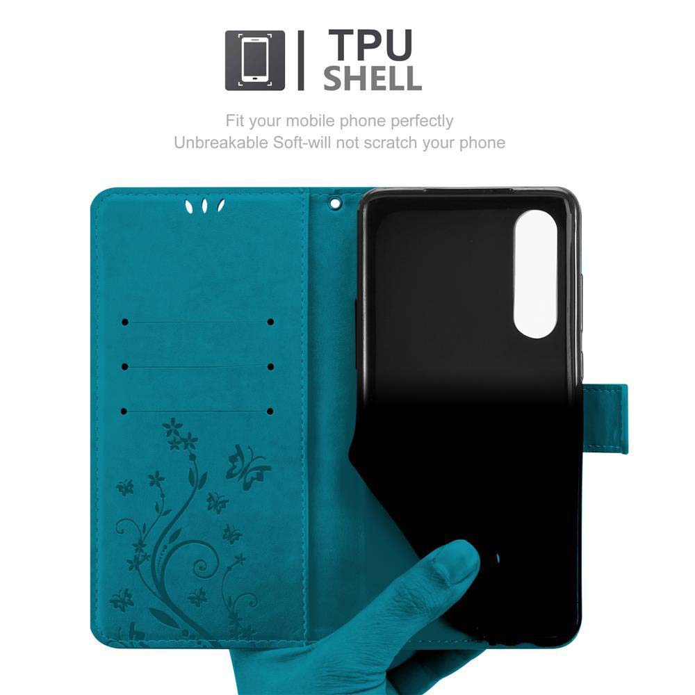 Custodia del telefono blu aperta con un telefono nero all'interno. Ha un design floreale. Lo sfondo è bianco.