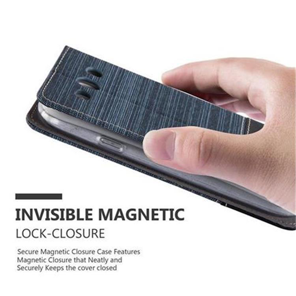 Una mano che tiene un telefono in una custodia di tessuto blu con chiusura magnetica.