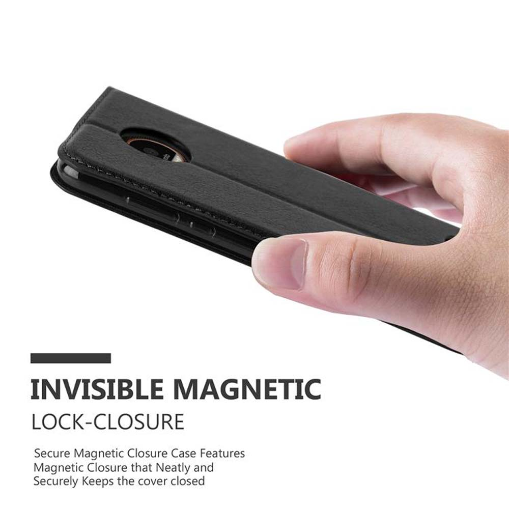 Una funda negra para teléfono, cerrada, sostenida por una mano.