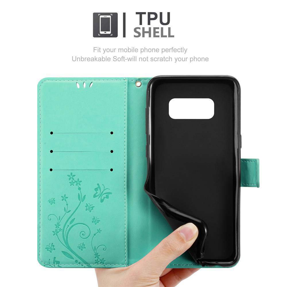 Una mano tiene in mano una custodia per telefono. La custodia è aperta e mostra un telefono all'interno. Verde acqua e nero.