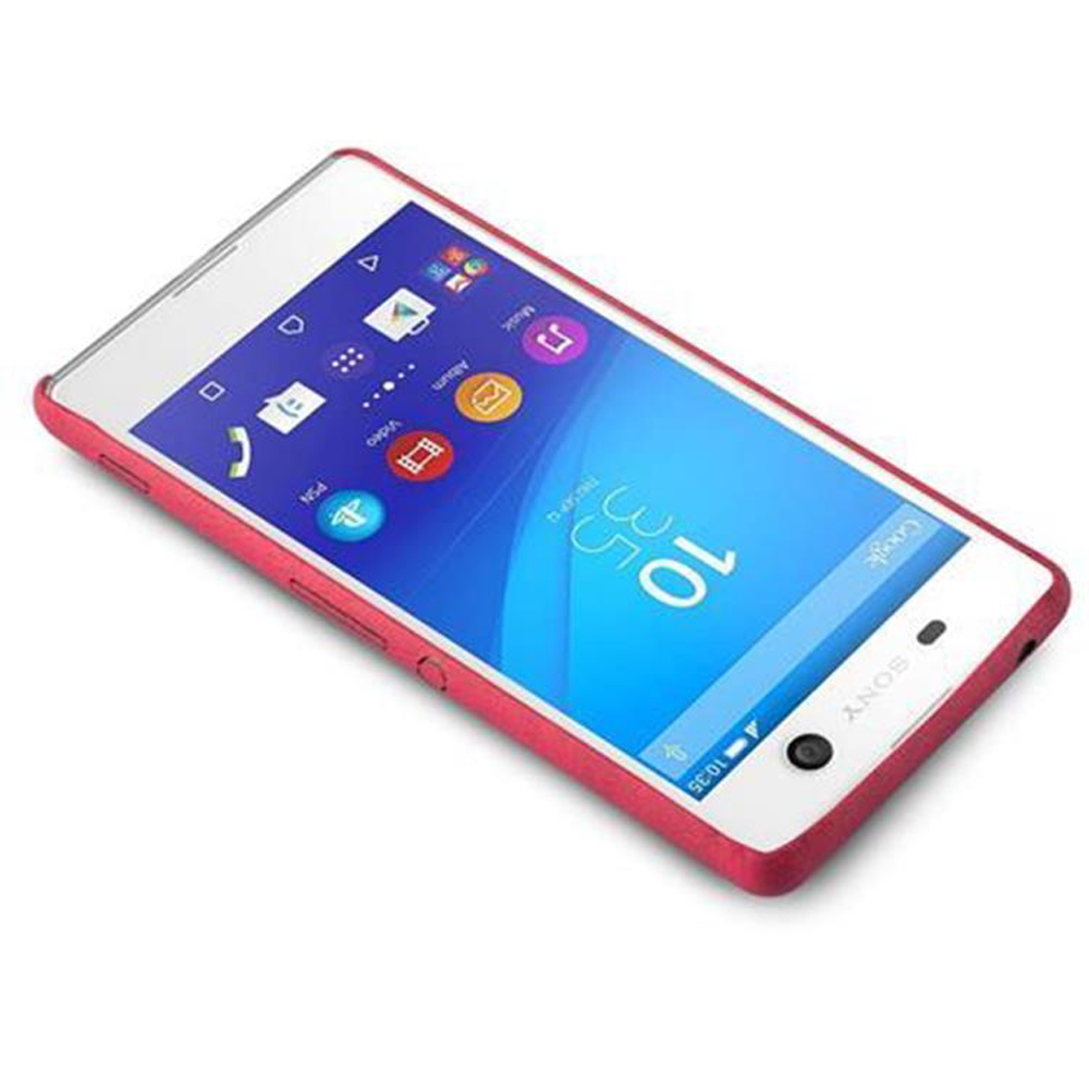 Un teléfono blanco con funda roja. La pantalla muestra iconos y un reloj. El teléfono está en ángulo sobre una superficie blanca.
