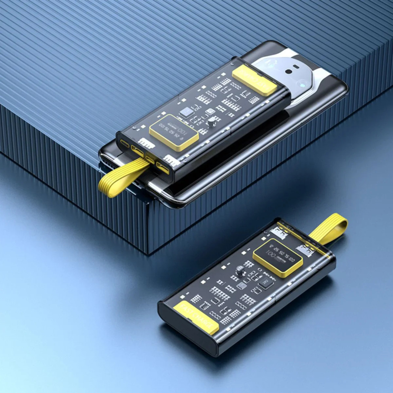 Zwei schwarz-gelbe Powerbanks sind auf einer blauen Oberfläche positioniert. Die obere ist geöffnet und zeigt Details.
