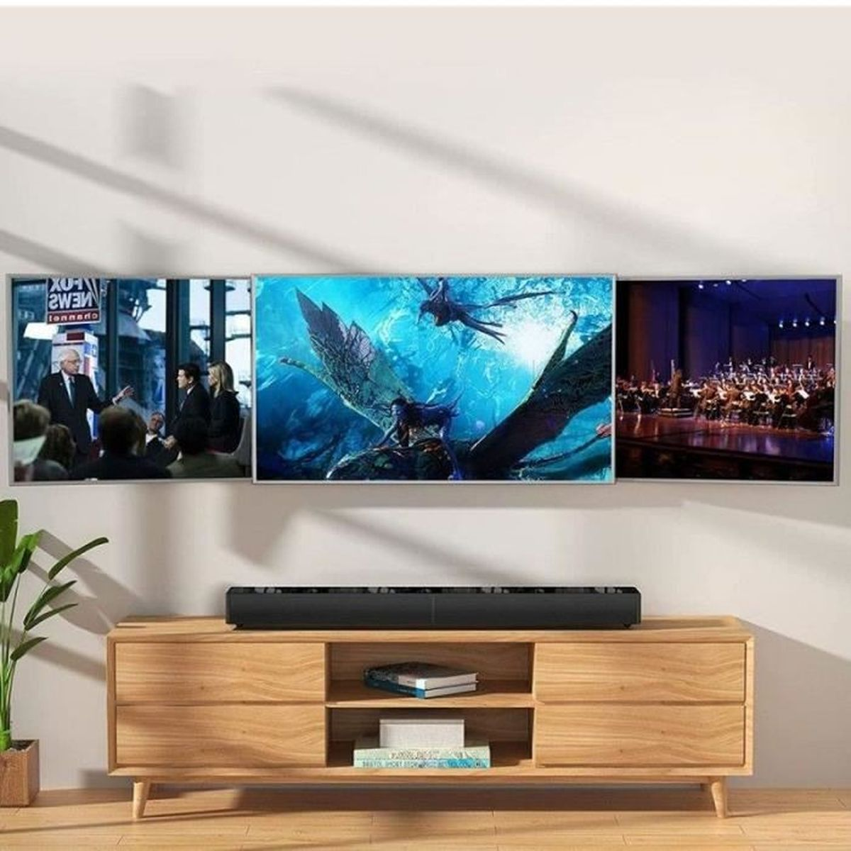 Drei TVs an der Wand zeigen Bilder. Eine Soundbar darunter. Ein Holzschrank darunter.